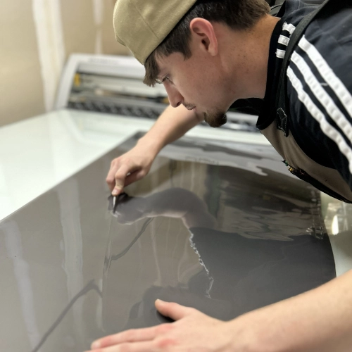 Tint Club Duluth installer carefully applying window tint film to a car window